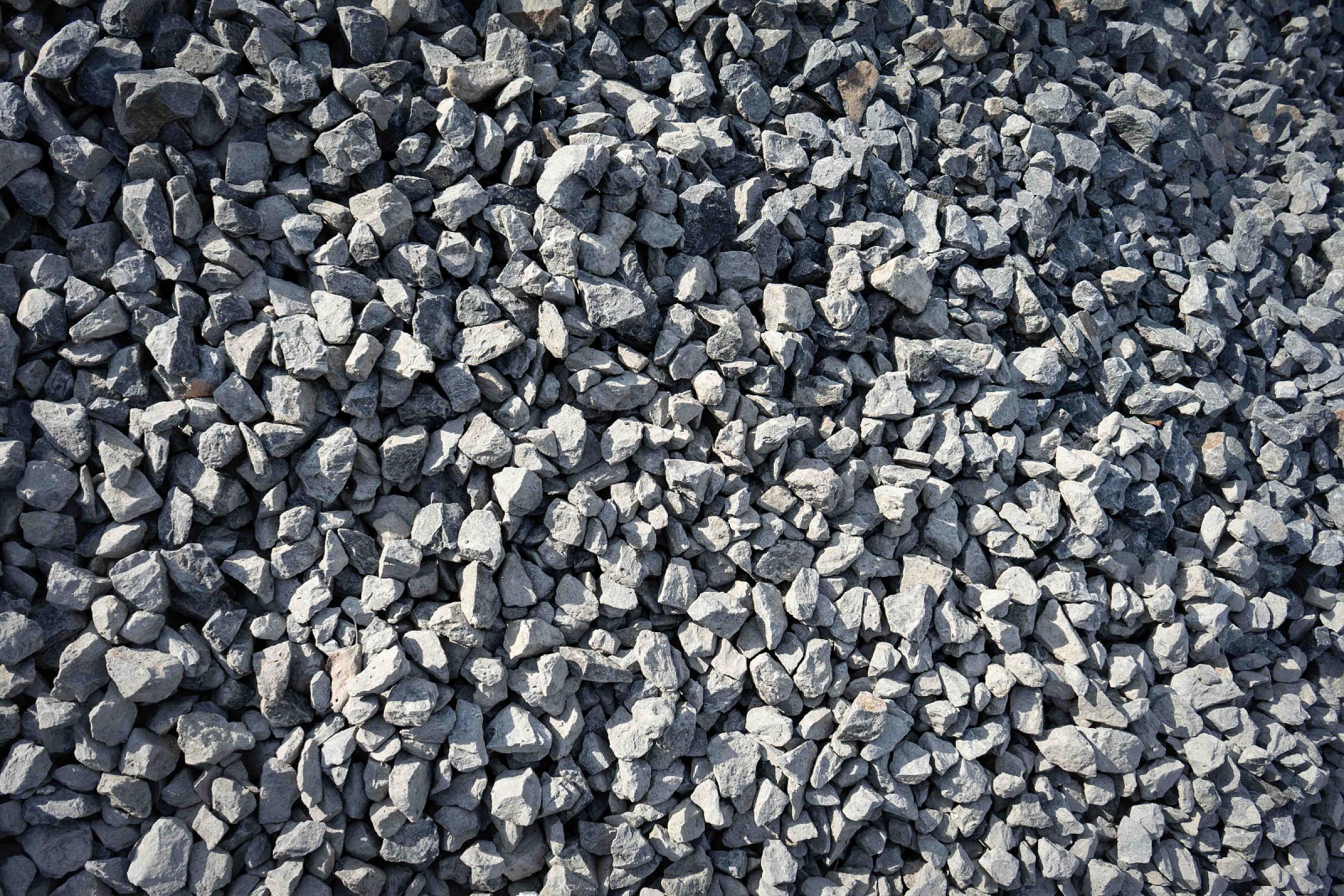 Haufen von grauem Basaltsplitt für Bau- und Gartenprojekte, angeboten von HTA GmbH.