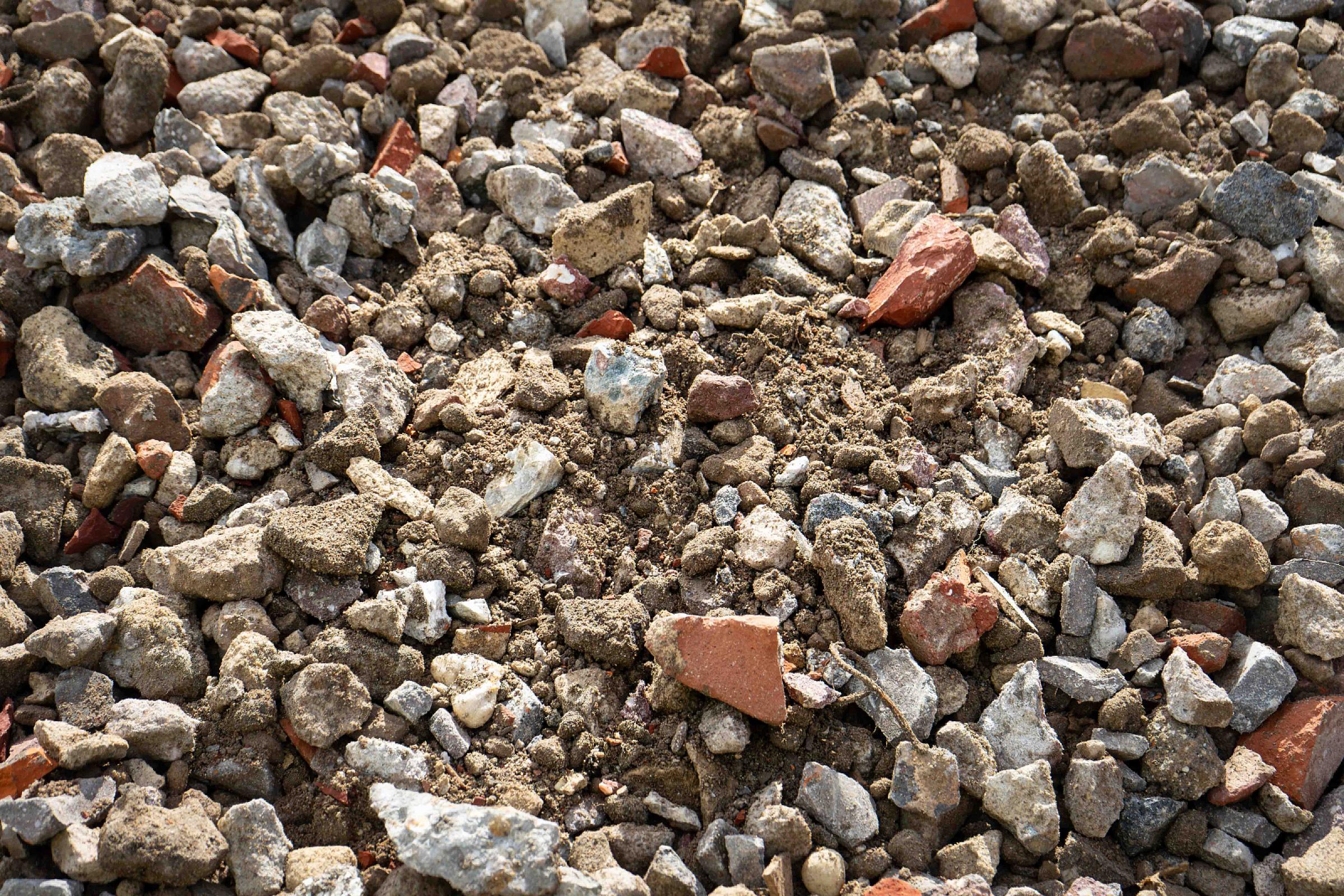Stapel aus verschieden großen Steinen und Ziegelbruch des RC-Recyclingschotters auf Baustelle.