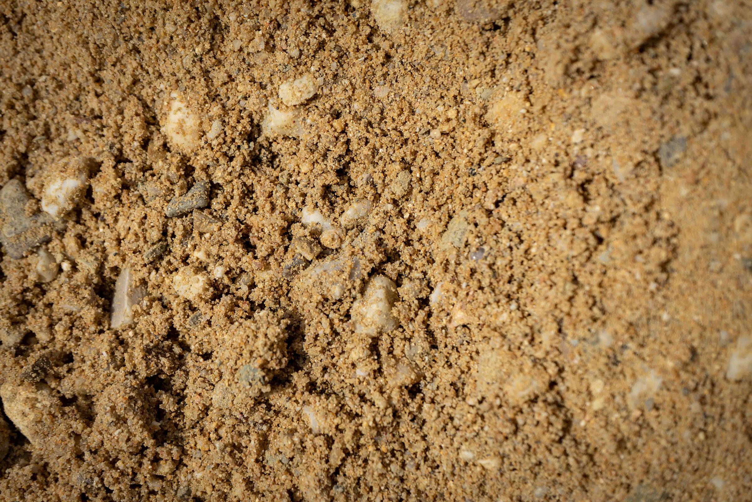 Betonkies der HTA GmbH, eine Mischung aus Sand und kleinen Steinen, Detailaufnahme der Textur.