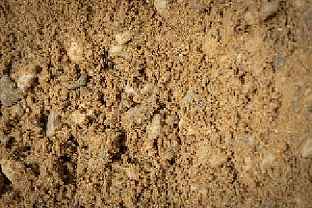 Betonkies der HTA GmbH, eine Mischung aus Sand und kleinen Steinen, Detailaufnahme der Textur.
