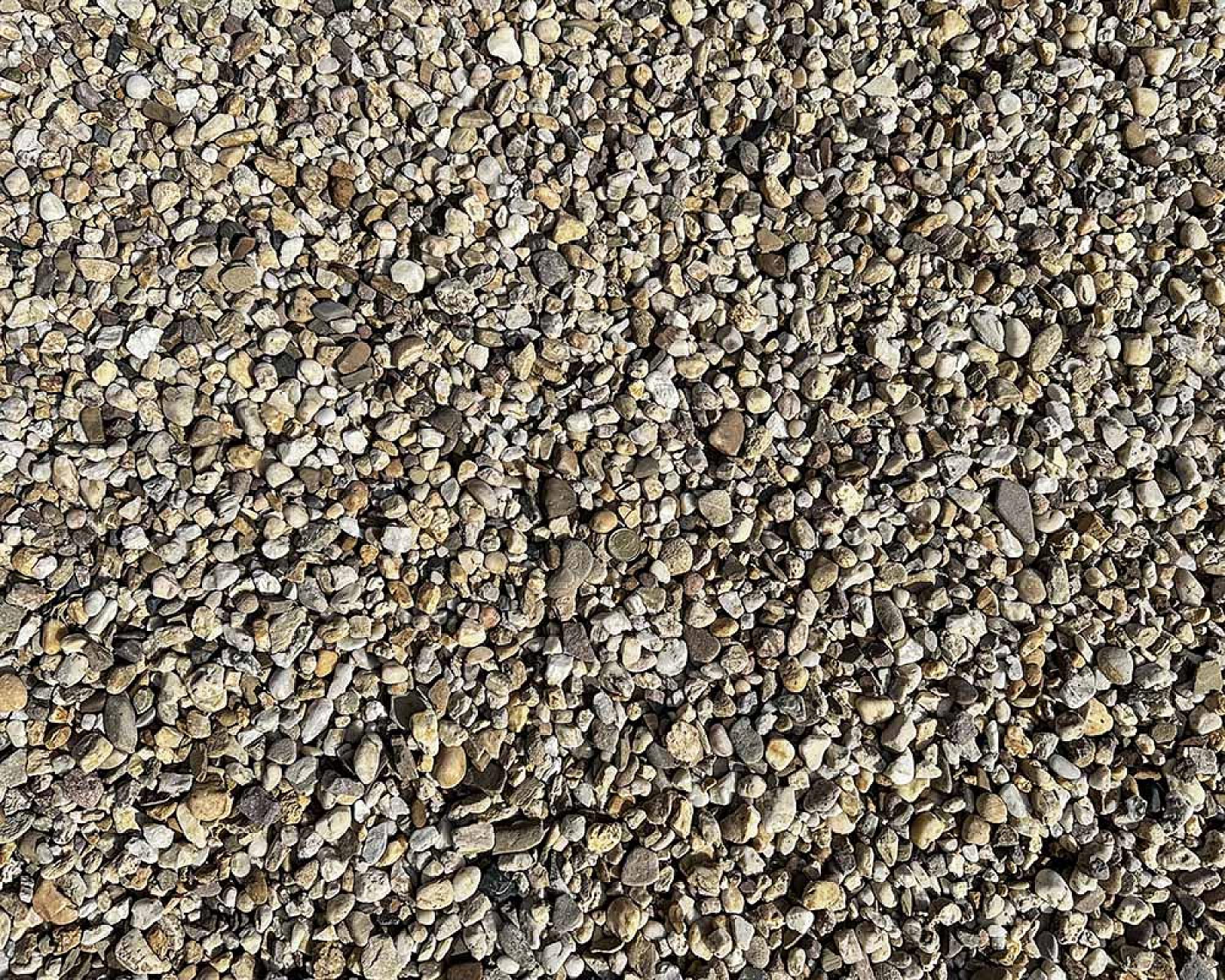 Gewaschener Rheinkies 16-32 mm in unterschiedlichen Grautönen auf einer Fläche gleichmäßig verteilt.