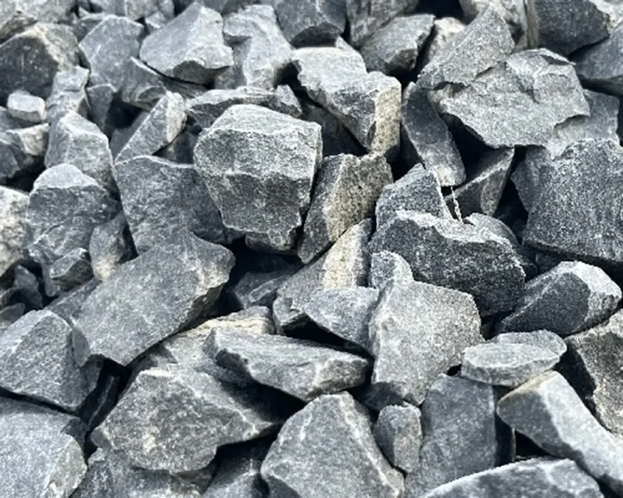 Graue Gabionensteine aus Basalt, unregelmäßig geformt, liegen dicht beieinander.