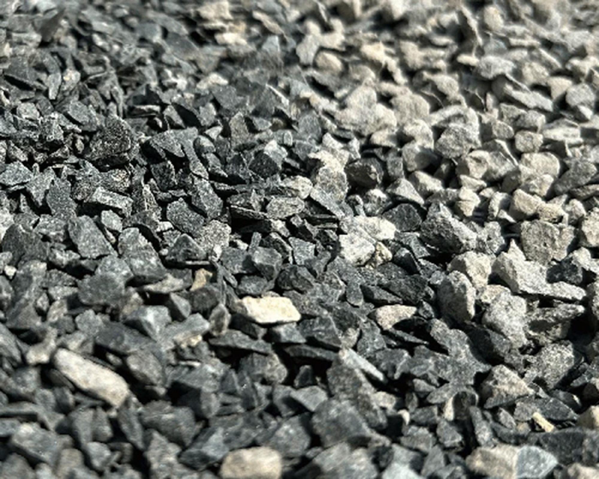 Fugensplitt aus Basaltkörnern in Nahaufnahme, grau-schwarze Steinstücke, ideal für Garten- und Landschaftsbau.