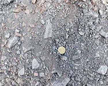 Schotter und Steine auf Bodenansicht, mit Münze für Größenvergleich. Natursteinmineralgemisch von Winfried Beiler GmbH.