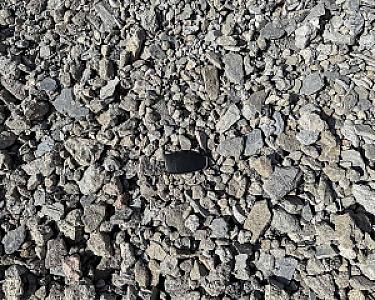 Haufwerk aus grobem Betonschotter, recycelter Betonbruch, ungleichmäßig verteilt, teils kantig, teils rund.