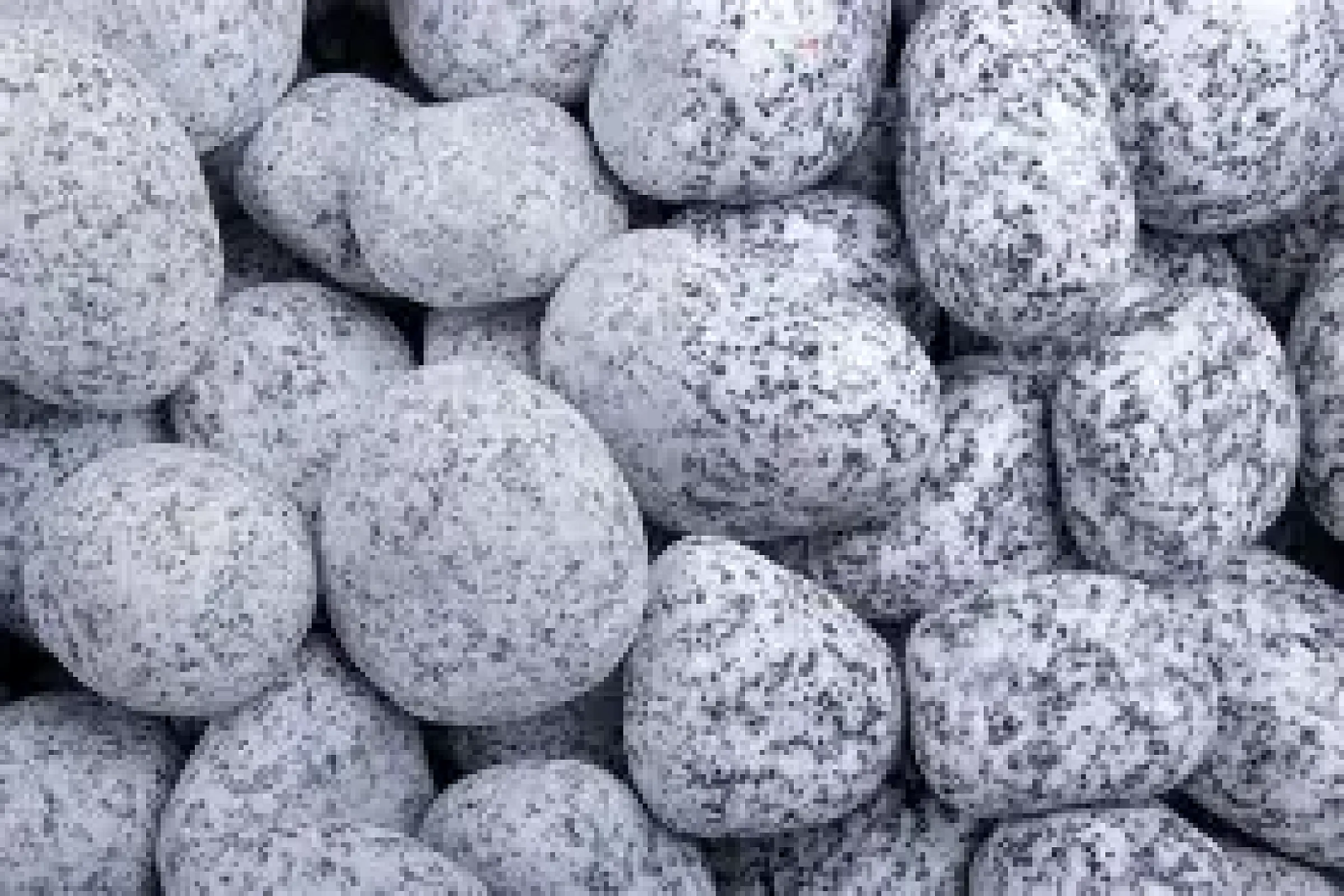 Getrommelte Gletscherkiese mit glatter Oberfläche und hellgrauer Farbe, bereit zur Verwendung im Landschaftsbau.