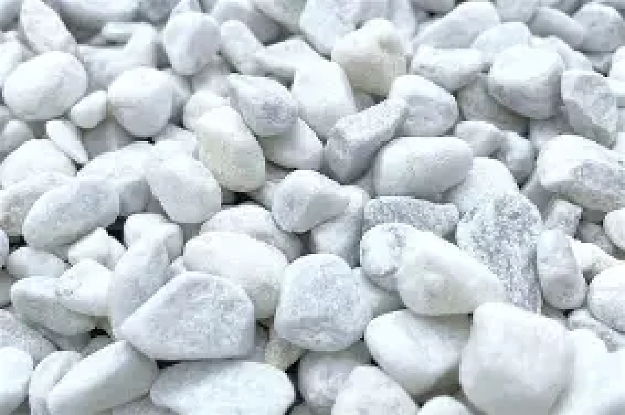 Getrommelte Carrara-Natursteine in verschiedenen Größen, weiß-grau gemustert.