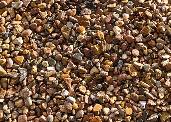Verschiedene bunte Weserkies-Steine der Marke Sommer Baustoffe GmbH + Co. KG in Nahaufnahme.