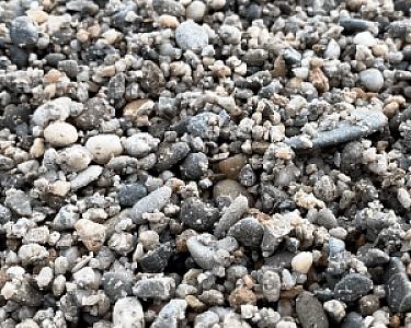 Nahaufnahme von gewaschenem Rheinkies mit verschiedenen grauen und beigen Steinen der Körnung 2-8.