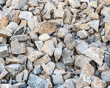 Bruchsteine aus Muschelkalk in verschiedenen Größen, ungleichmäßig gestapelt.