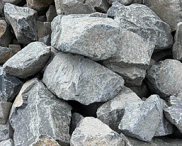 Basalt-Wasserbausteine in verschiedenen Größen für Bauprojekte, aufeinander gestapelt.