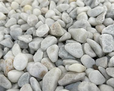 Nahaufnahme von weißem Marmor-Splitt mit variierenden Körnergrößen.