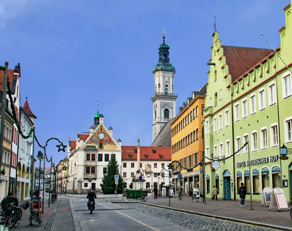 Historische Altstadt von Freising mit bunten Gebäuden, Kirchturm und weihnachtlicher Dekoration entlang der Straße.