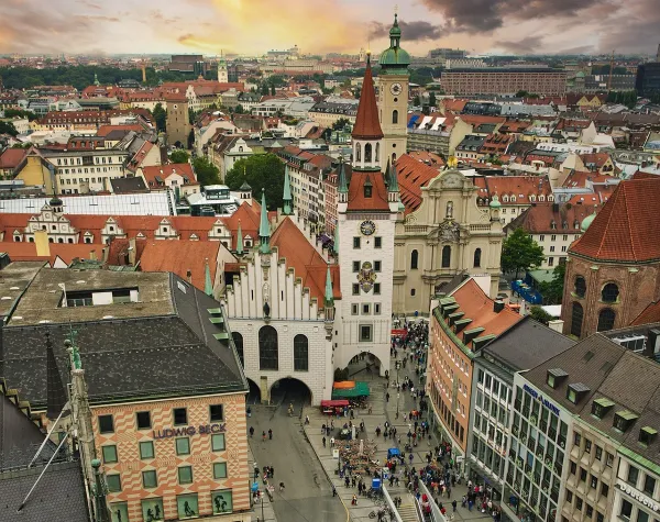 Stadtszene in München mit dem Alten Rathaus, umgeben von historischen Gebäuden und belebt durch zahlreiche Menschen.