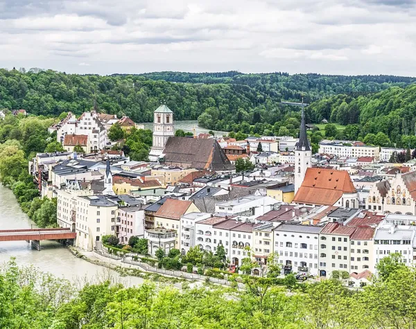 Stadtansicht von Rottal-Inn mit historischen Gebäuden, grüner Landschaft und Fluss im Vordergrund.