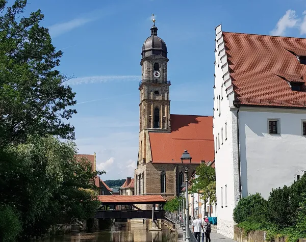 Historische Stadtansicht von Amberg mit Kirchturm und Fachwerkhäusern an einem sonnigen Tag.