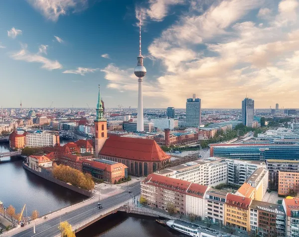Berliner Skyline mit Fernsehturm, Spree und Marienkirche unter blauem Himmel.