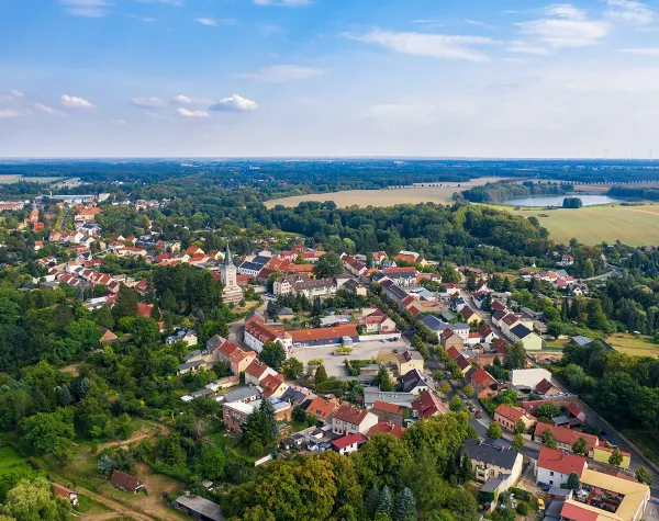 Luftaufnahme von Biesenthal im Barnim, mit Kirche und umliegender grüner Landschaft.