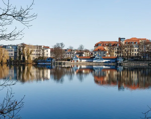 See mit Uferpromenade und historischen Gebäuden in Märkisch-Oderland, klare Spiegelung im Wasser.