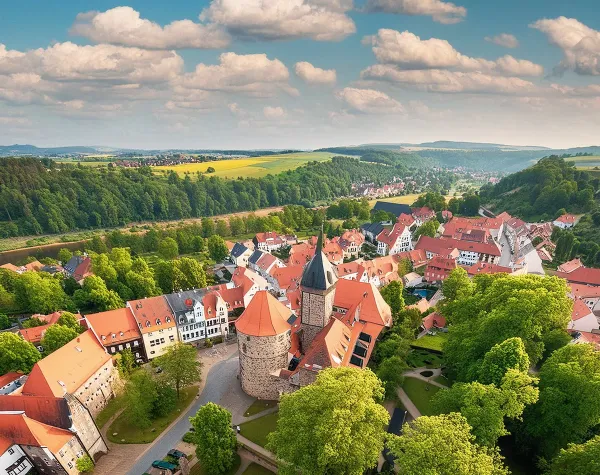 Panorama des Landkreises Nordsachsen mit grüner Landschaft und historischen Gebäuden unter blauem Himmel.