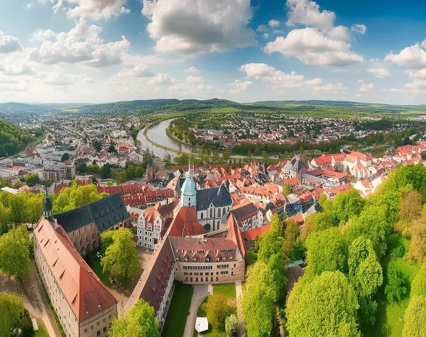Panorama der Stadt Halle (Saale) mit Fluss, historischen Gebäuden und grüner Landschaft.
