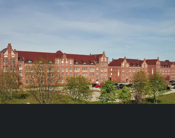 Historische Backsteingebäude in Stendal, mit roten Dächern und blauen Himmel im Hintergrund.